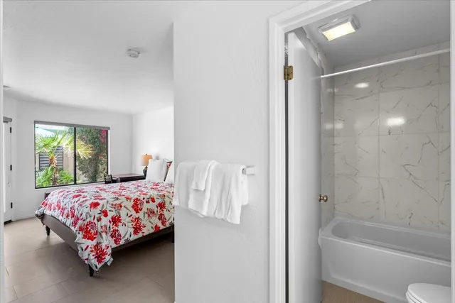 a bedroom with a bed and a window with couch