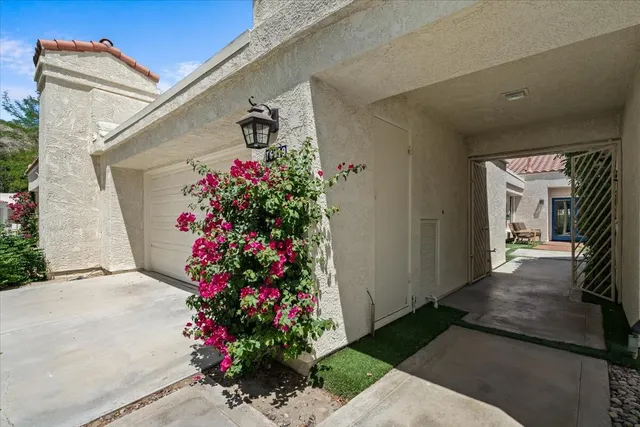 a view of a porch with flowers and potted plants