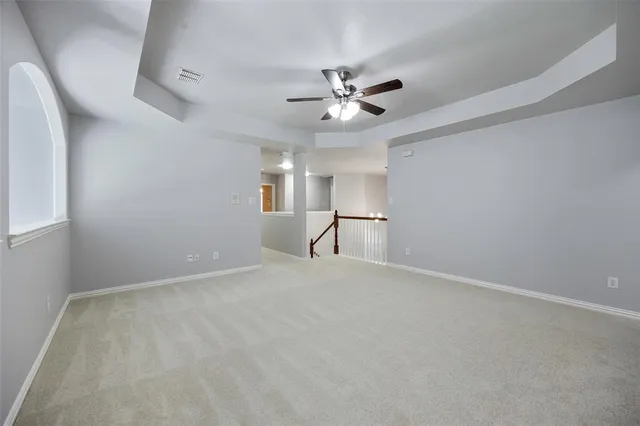 an empty room with chandelier fan and closet