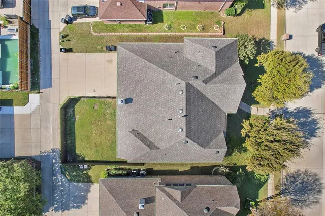 an aerial view of a house with a yard and a large tree