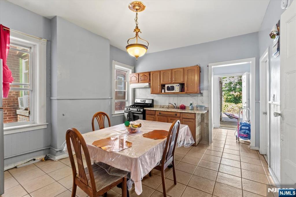 331 Market Street Paterson, NJ 07501 - Photo 23 of 25 a kitchen with a table chairs a sink dishwasher stove and cabinets