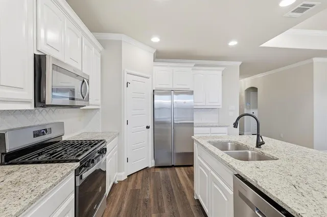 a kitchen with stainless steel appliances granite countertop a sink stove and refrigerator