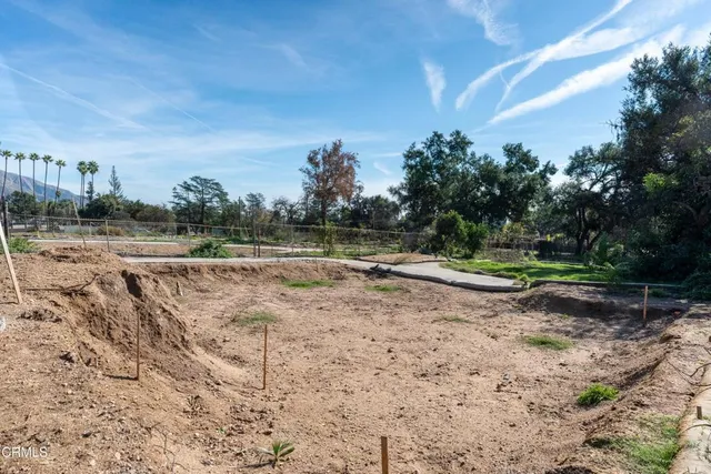 a view of a dry yard with wooden fence