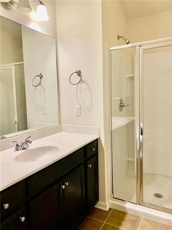 a bathroom with a shower sink vanity and a mirror