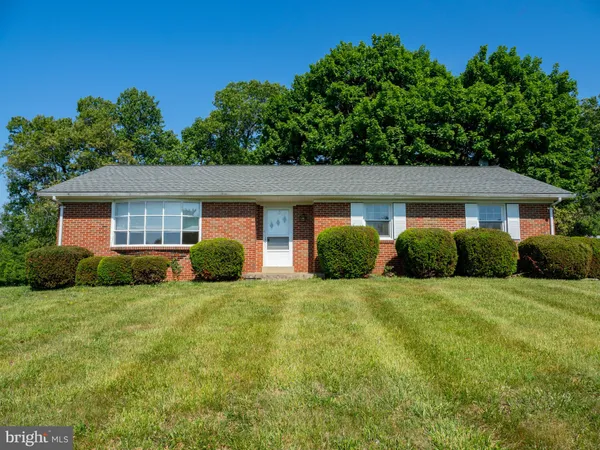 a view of a house with backyard and trees