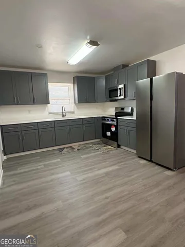 a large kitchen with stainless steel appliances granite countertop a refrigerator and a stove