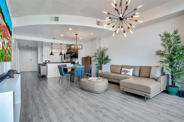 a view of a big room with a chandelier fan and windows
