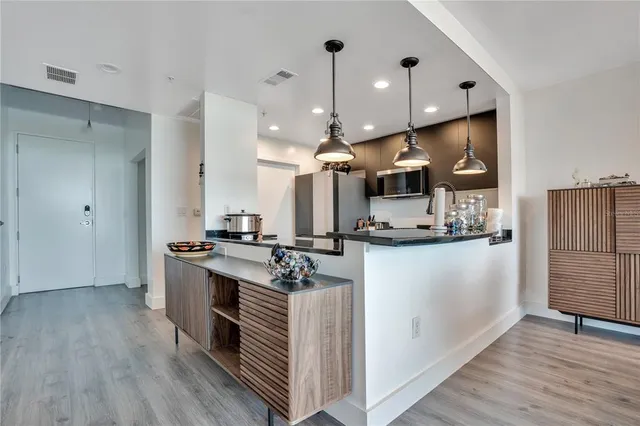 a kitchen with stainless steel appliances granite countertop a stove a sink and a microwave