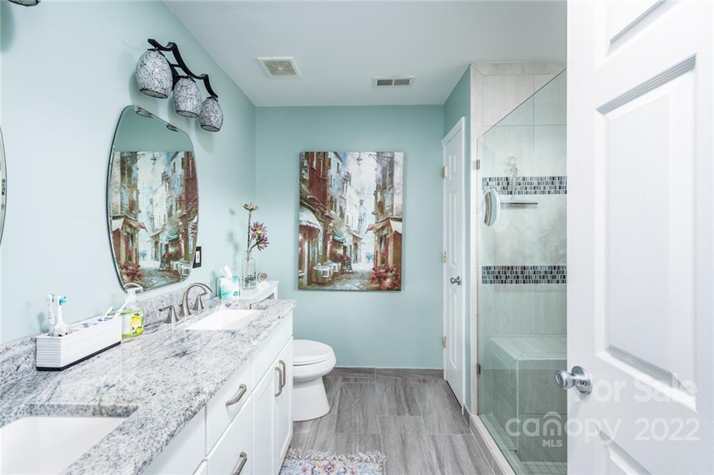 3541 Vandora Springs Road Fort Mill, SC 29708 - Photo 17 of 40 a bathroom with a granite countertop sink a toilet a shower and a mirror