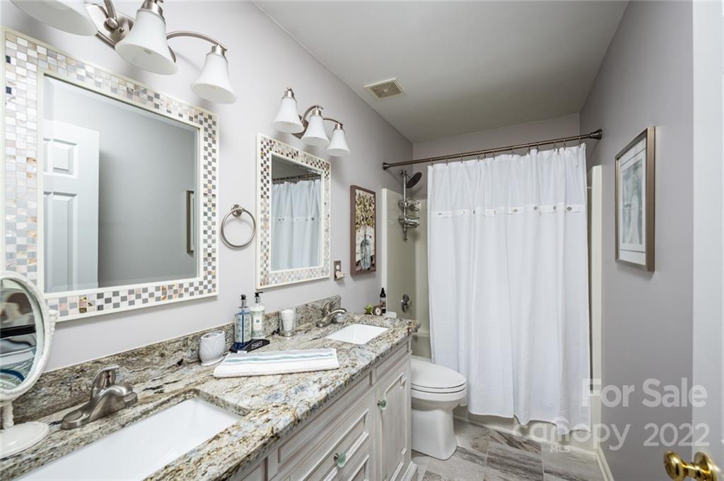 3541 Vandora Springs Road Fort Mill, SC 29708 - Photo 21 of 40 a bathroom with a granite countertop sink a toilet and a mirror