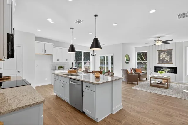 a kitchen with stainless steel appliances granite countertop a sink stove and refrigerator