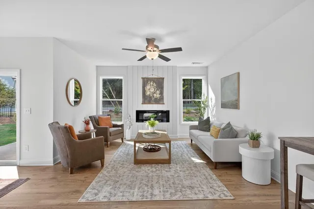 a living room with furniture a table and a large window
