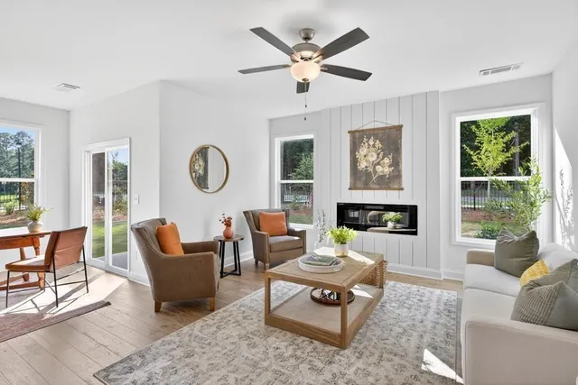 a living room with furniture a fireplace and a large window