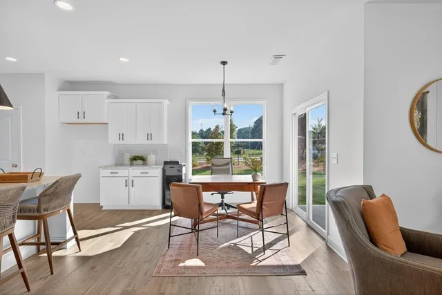 a living room with furniture kitchen view and a wooden floor