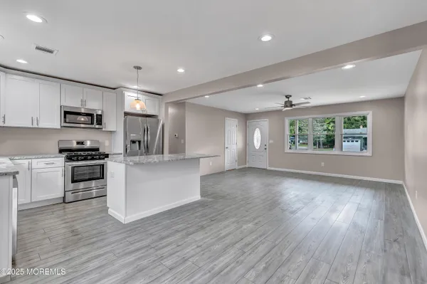 a view of kitchen with sink stainless steel appliances and window