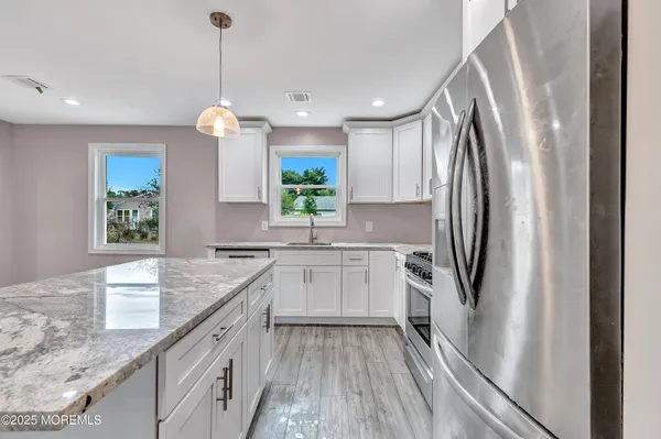 a kitchen with stainless steel appliances granite countertop a refrigerator a sink and a stove