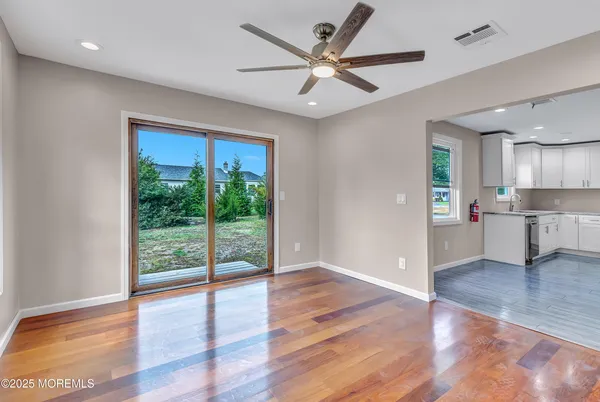 a view of a big room with wooden floor and a ceiling fan