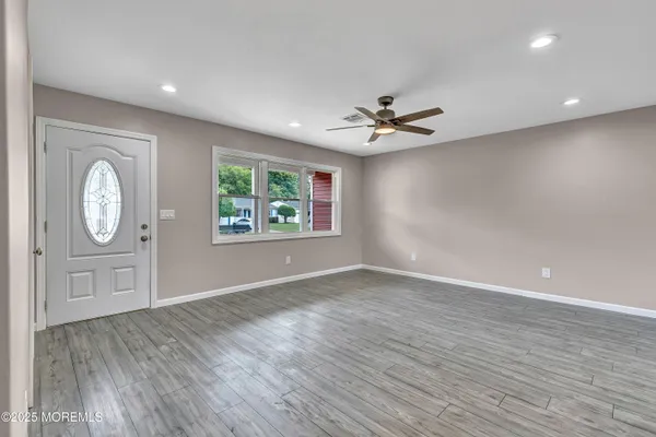 a view of an empty room with a window and a ceiling fan