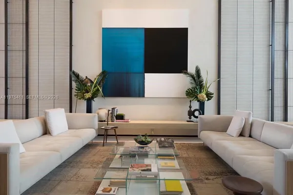 a view of a refrigerator in kitchen and an empty room