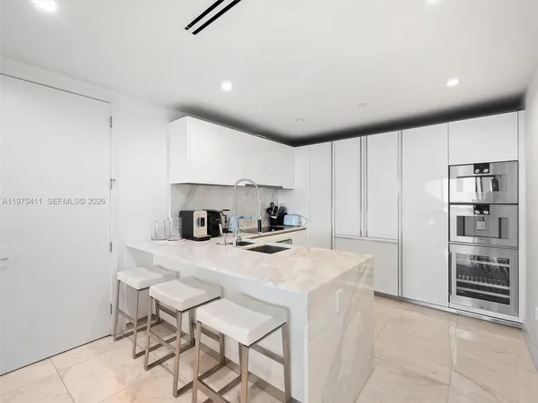 a kitchen with a sink a stove and chairs