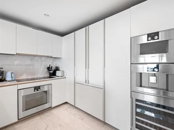 a kitchen with stainless steel appliances granite countertop a refrigerator and a stove top oven