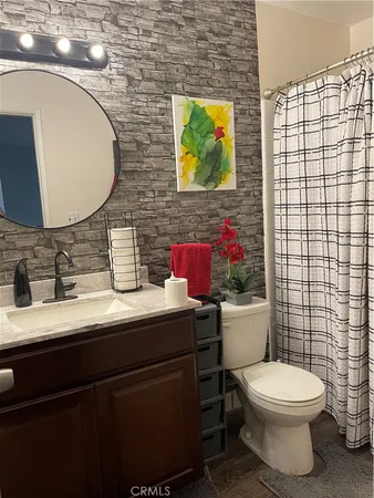 a bathroom with a toilet sink vanity and mirror