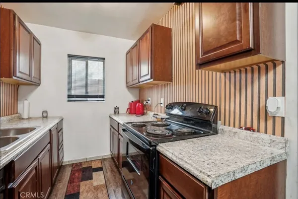 a kitchen with granite countertop a stove and a sink