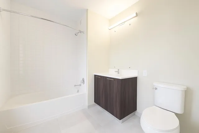 an empty room with wooden floor and windows with curtains