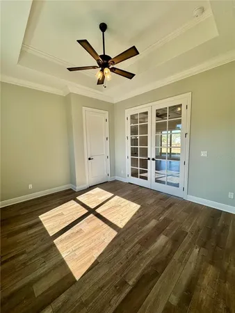 a view of a room with wooden floor and a ceiling fan