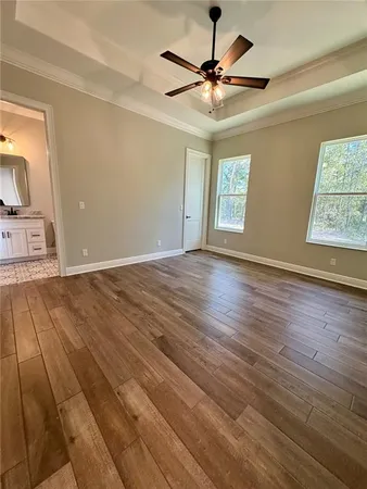a view of an empty room with window and wooden floor