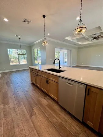 a kitchen with stainless steel appliances granite countertop a sink a counter space and wooden floor