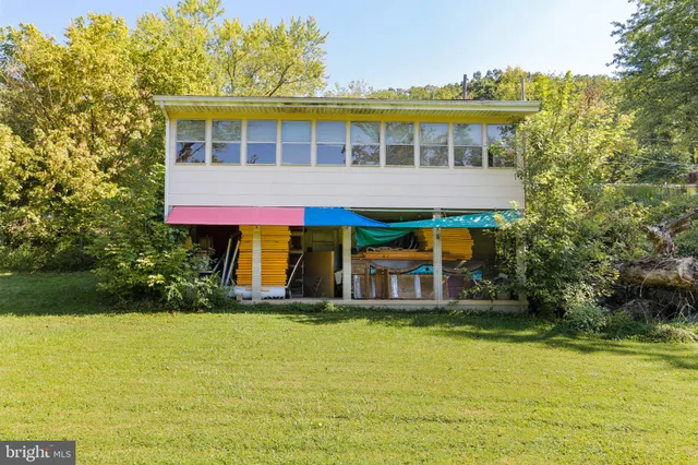 a view of a large pool with lawn chairs under an umbrella