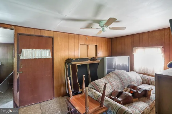 a living room with furniture a ceiling fan and a window