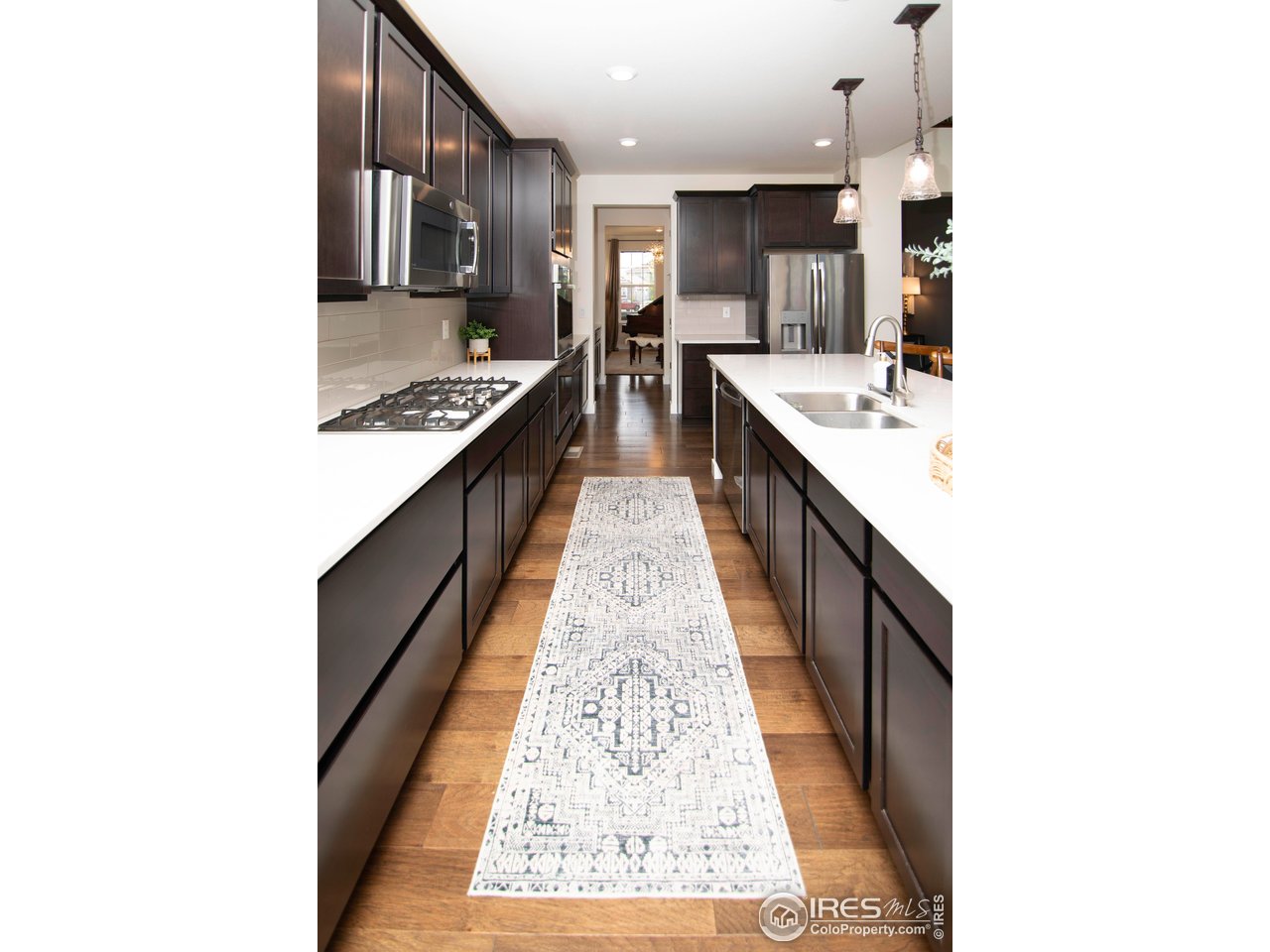 7086 Thunderview Drive Timnath, CO 80547 - Photo 14 of 38 a large kitchen with kitchen island granite countertop a sink and a stove