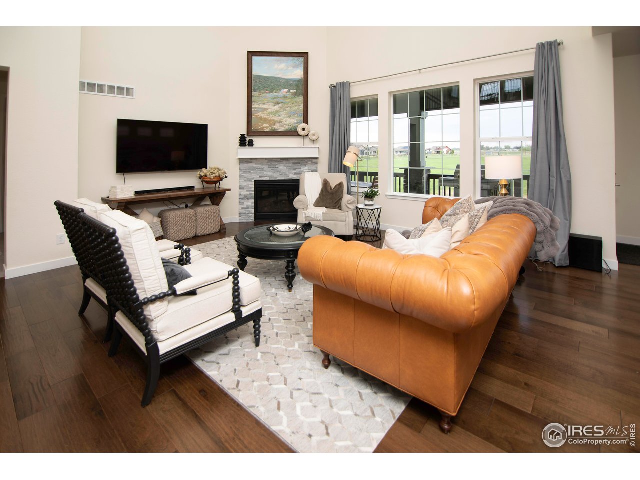 7086 Thunderview Drive Timnath, CO 80547 - Photo 16 of 38 a living room with furniture a flat screen tv and a fireplace