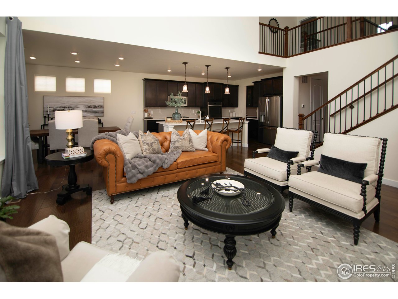 7086 Thunderview Drive Timnath, CO 80547 - Photo 17 of 38 a living room with furniture a rug and kitchen view