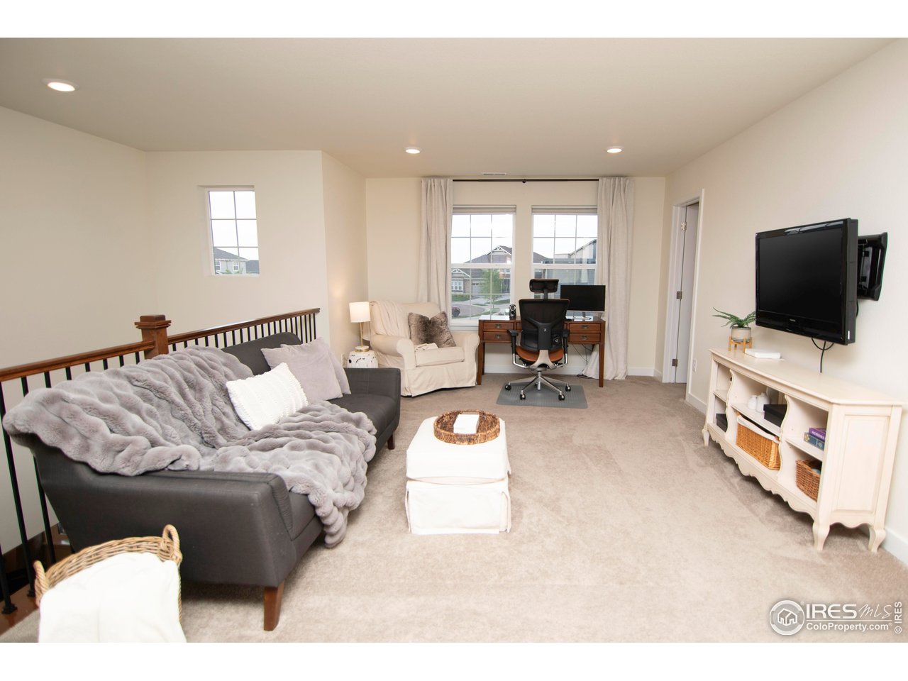 7086 Thunderview Drive Timnath, CO 80547 - Photo 21 of 38 a living room with furniture and a flat screen tv