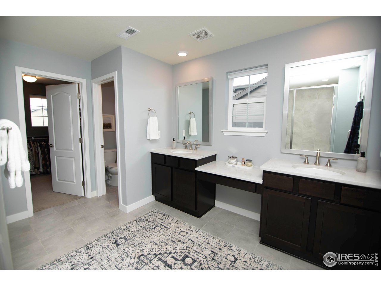 7086 Thunderview Drive Timnath, CO 80547 - Photo 23 of 38 a bathroom with a sink double vanity granite and a mirror