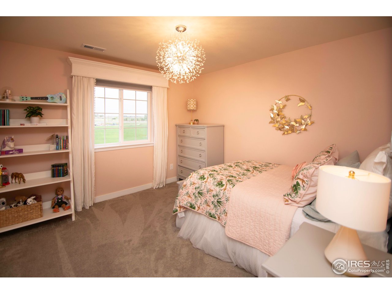 7086 Thunderview Drive Timnath, CO 80547 - Photo 28 of 38 a bedroom with a bed and a chandelier