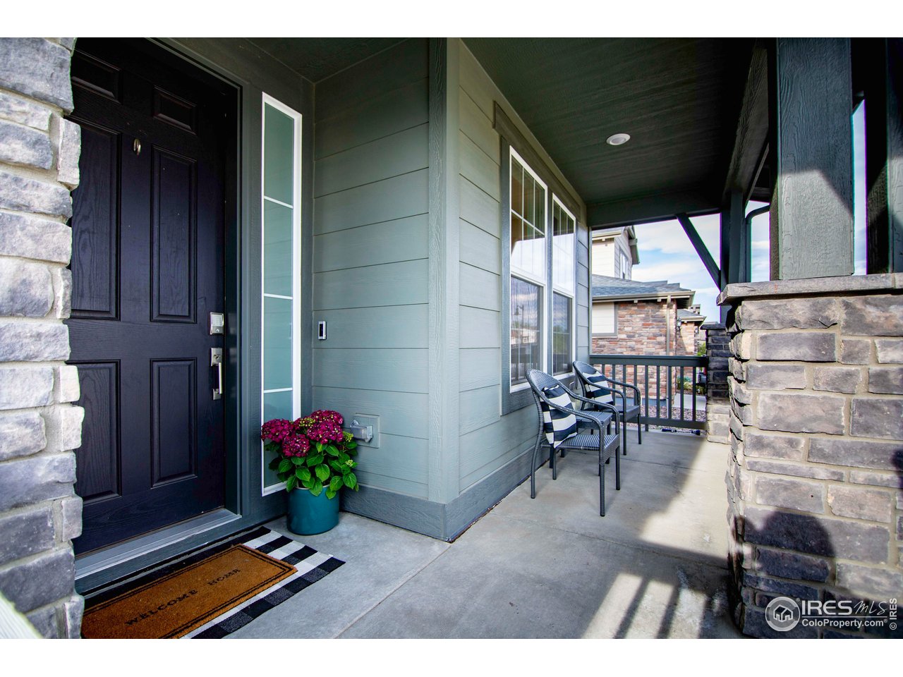 7086 Thunderview Drive Timnath, CO 80547 - Photo 4 of 38 a balcony with chairs potted plants and wooden floor