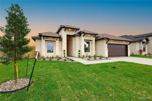a front view of a house with a yard and trees