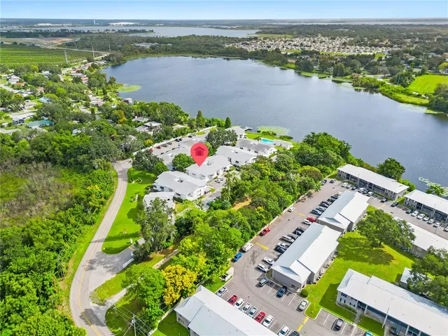 an aerial view of ocean and residential houses with outdoor space