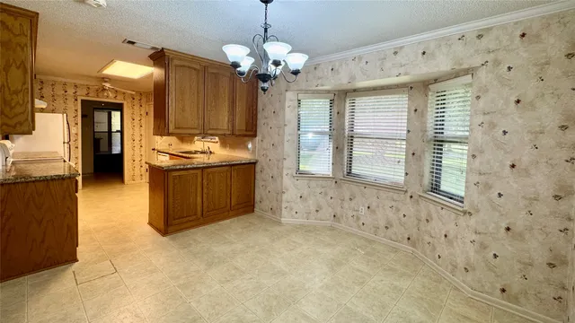 a spacious bathroom with a granite countertop sink a mirror and a bathtub
