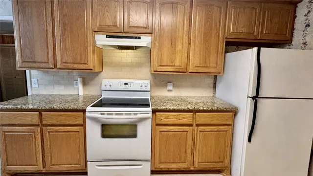 a kitchen with granite countertop cabinets and appliances