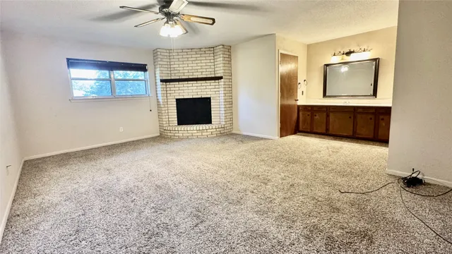 an empty room with windows and fireplace