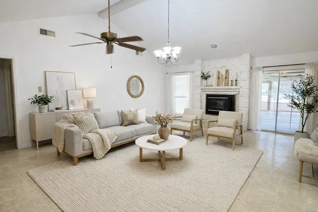 a living room with furniture a chandelier and a flat screen tv