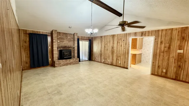 a view of a livingroom with a fireplace a chandelier and stairs
