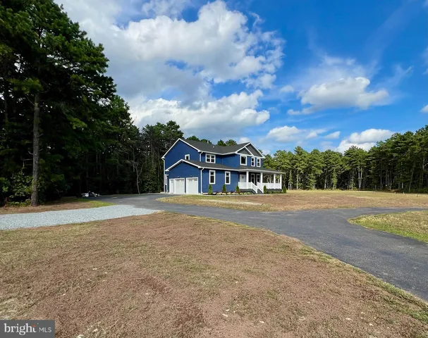 a view of house with outdoor space and trees in the background
