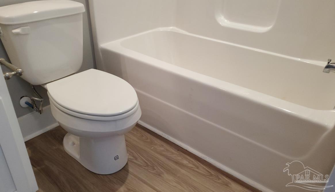 9822 Utopia Drive, Unit E Pensacola, FL 32514 - Photo 5 of 13 a bathroom with a toilet and a bathtub