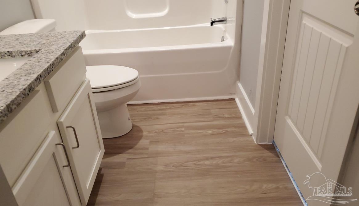 9822 Utopia Drive, Unit E Pensacola, FL 32514 - Photo 6 of 13 a bathroom with a granite countertop shower and a toilet